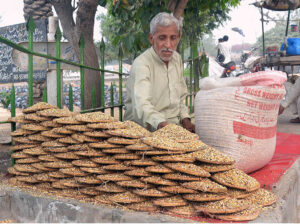 A vendor displaying pigeons food to attract customers at his roadside setup