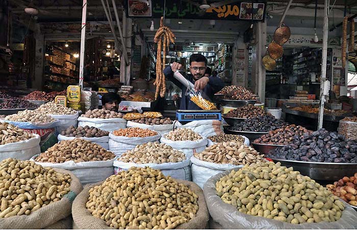 A shopkeeper arranging and displaying dry fruit to attract the ...