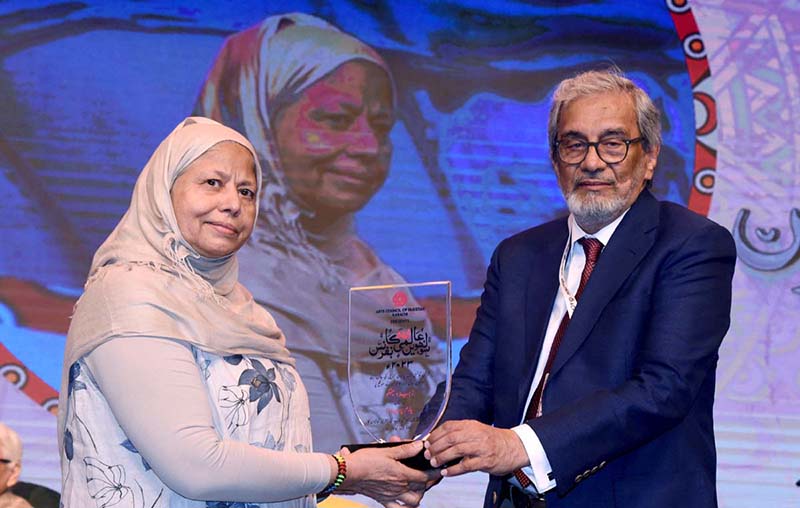 Caretaker Sindh Chief Minister Justice (R) Maqbool Baqar gives away a souvenir to a leading regional literary figure during the International Urdu Conference at the Arts Council of Pakistan.