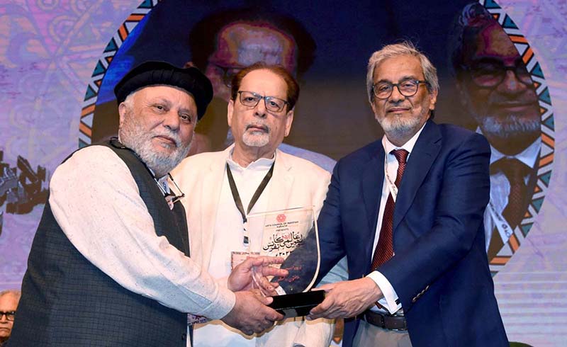 Caretaker Sindh Chief Minister Justice (R) Maqbool Baqar gives away a souvenir to a leading regional literary figure during the International Urdu Conference at the Arts Council of Pakistan.