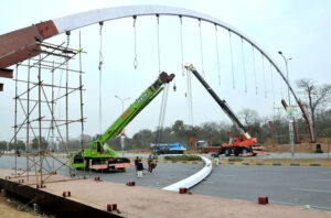 CDA workers busy installing pedestrian bridge with the help of cranes at Srinagar Highway in the Federal Capital