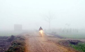 A cyclist on his way during heavy fog in the city during morning time.