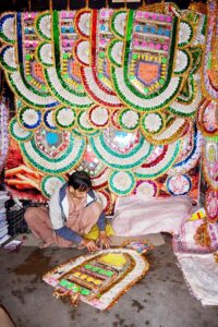 A vendor preparing the money garlands for wedding at his workplace