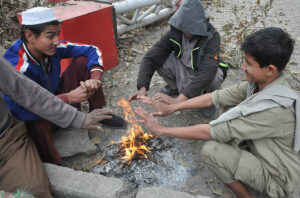 People are sitting around fire, warm themselves as the temperature dropped in Federal Capital