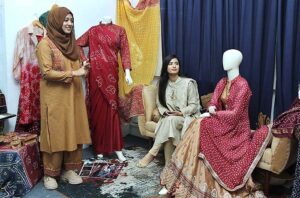 A student viewing creative work during Annual 18th Degree Show at SABS University of Art, Design and Heritages Jamshoro.