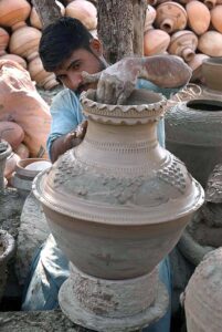 Craftsman preparing clay-made pitchers at his workplace at kumharpara.