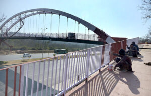 Workers paint the grills of a pedestrian bridge on Srinagar Highway.