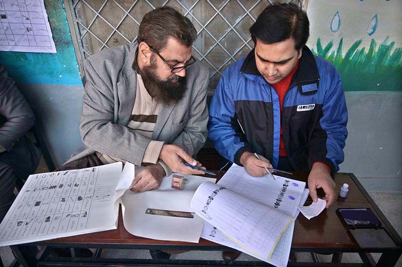 Polling Officers Searching The Name Of Voter In Voter S List In The   APP08 080224Rawalpindi 