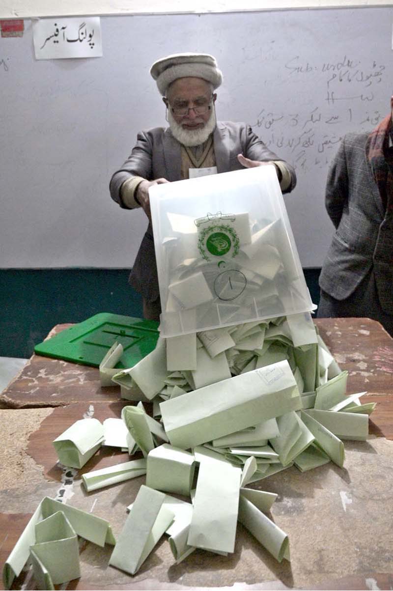 Election official opens ballot box to count votes after polls end