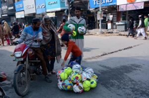  A vendor selling footballs to earn his livelihood