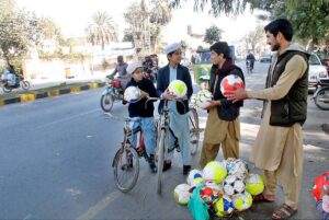 A vendor selling footballs to earn his livelihood. 