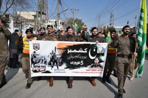 Passengers viewing banner installed on a train to mark Kashmir Solidarity Day at Cantt Railway Station