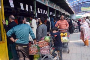 People purchasing vegetables from Ramzan Bachat Bazar organized by local government during Holy month of Ramadan at Model Bazar Johar Town.