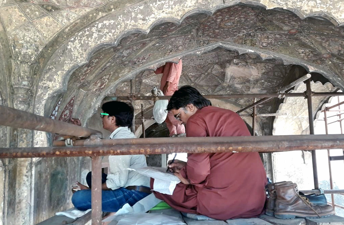 Talented painter applying artwork to bring life on the historical wall ...