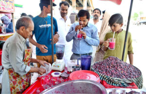 People drinking summer drink from vendor to get relief from hot weather in the city.