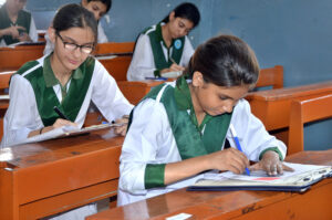 Students solving question paper during annual examination of HSSC part II 2024 (Class XII) at Nazareth Girls College.