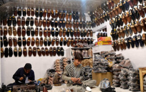 Cobblers making traditional shoes (Pishawari chappal) by hand in the traditional way at his workplace.