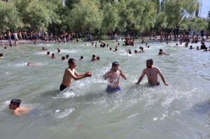 Youngster enjoying while bathing in water pound to get relief from hot weather in the city.