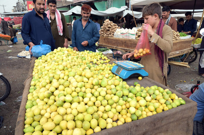 A vendor displaying seasonal fruit lemon to attract customers at Fruit ...