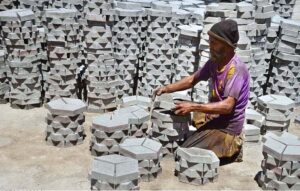 A labourer busy in arranging cemented tiles at Western Bypass.