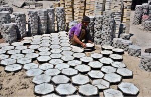 A labourer busy in arranging cemented tiles at Western Bypass.