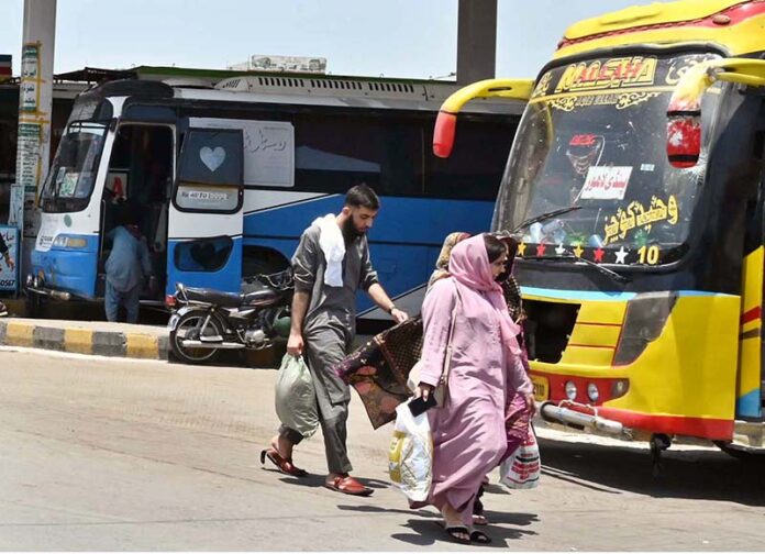 A family arrives at Pirwadhai Bus Stand to travel to their hometowns to celebrate Eid ul Azha with their loved ones