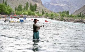 A person catching fishs at the Uper Kachura Xhoq lake in the mountain area of north Pakistan.