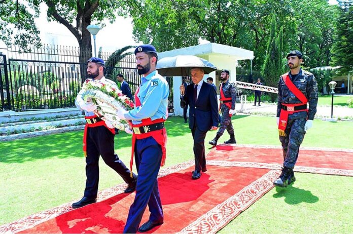 Prime Minister Muhammad Shehbaz Sharif laying a floral wreath at the ...