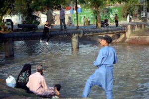 Youngsters jumping and bathing in canal to get relief from hot weather in the city