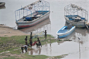 Nomad children are busy in catching fish with the cloth net along the banks of the Ravi River.