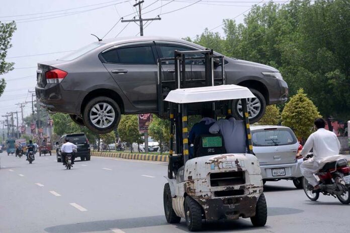 A traffic warden moving an illegally parked car with the help of lifter