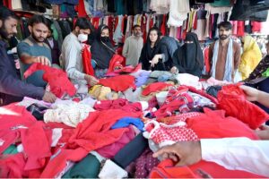 People busy selecting and purchasing second hand clothes from vendor at weekly Bazaar in the Federal Capital