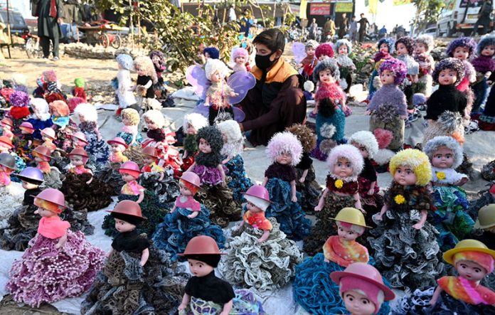 A vendors displaying and selling plastic dolls to attract the customer at roadside setup