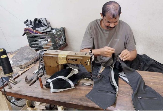 A skilled worker crafts export-quality jackets at a local factory