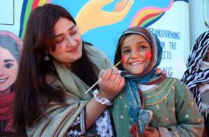 Woman making a painting on a child face during the 2nd Day of PDA Food & Culture family Festival with the support of UNICEF at Regi Model Town Park