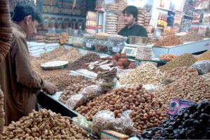 A vendor arranges and displays a variety of dry fruits at his shop as demand surges after dropping the temperature in the metropolis