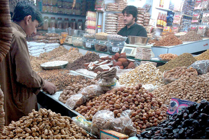 A vendor arranges and displays a variety of dry fruits at his shop as demand surges after dropping the temperature in the metropolis