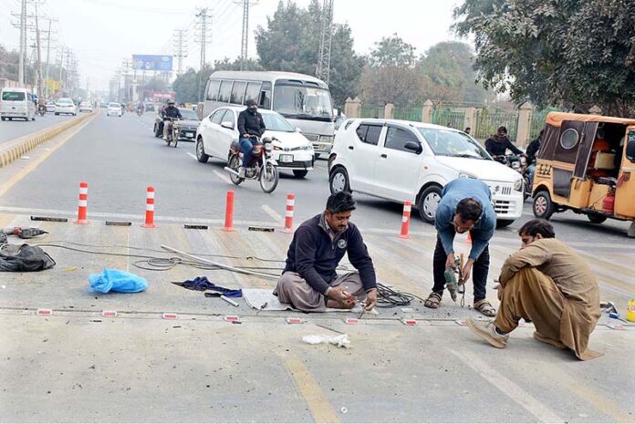 Electricians busy laying the wire of the traffic signal at Eid Gah Chowk