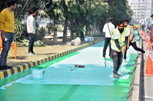 LDA workers construct separate green tracks for motorcycles and bicycles on Ferozepur Road to promote eco-friendly commuting in the city.