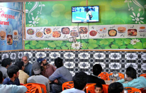 People watching ICC Champion Trophy cricket match playing between Pakistan and India on TV in a local restaurant in the federal capital.