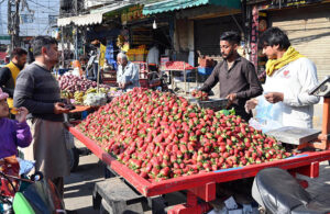 A man buys purchasing ripe Fresh strawberries from a roadside vendor in the city.