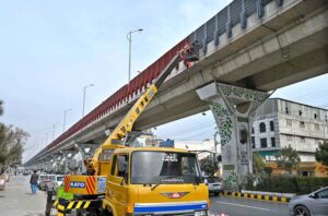 Labourers are busy painting the protection grill along the Metro Bus Route on Murree Road.