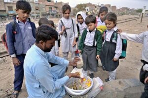 A street vendor selling traditional channa chaat to schoolchildren at old Civil line.