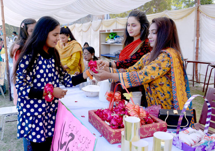 Female students purchasing the flower bracelet from the stall during the spring festival at La Salle Higher Secondary School