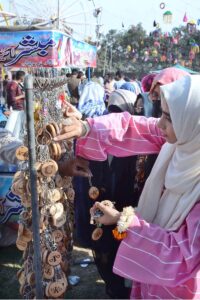 Students selecting key chain at a stall during Gur Mela of 10th Lyallpur Arts & Literature Festival at University of Agriculture Faisalabad (UAF).