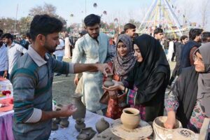 Students selecting key chain at a stall during Gur Mela of 10th Lyallpur Arts & Literature Festival at University of Agriculture Faisalabad (UAF).