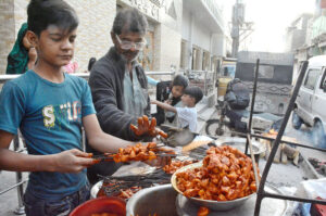 A vendor is setting his road side barbecue stall at Korangi.