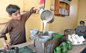 A young vendor making tea for customers at a shop in Korangi area.