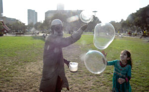 An old man selling water bubbles at the historic Frere Hall.