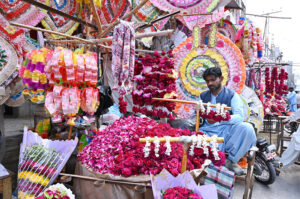 A vendor arranging flowers to attract the customers at his roadside setup.